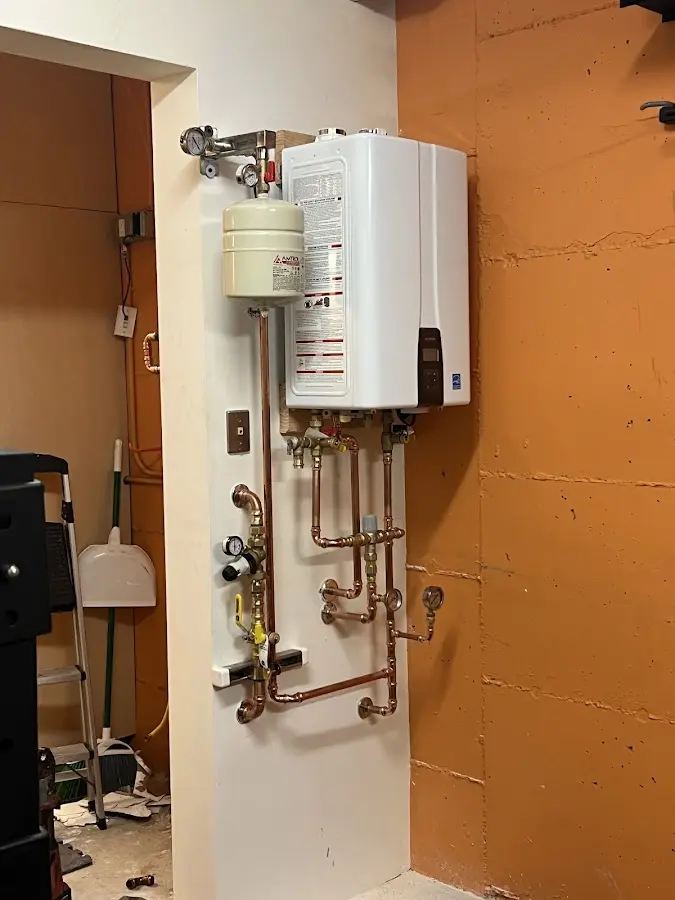 Plumbing technician inspecting water heater connections in Thermalito